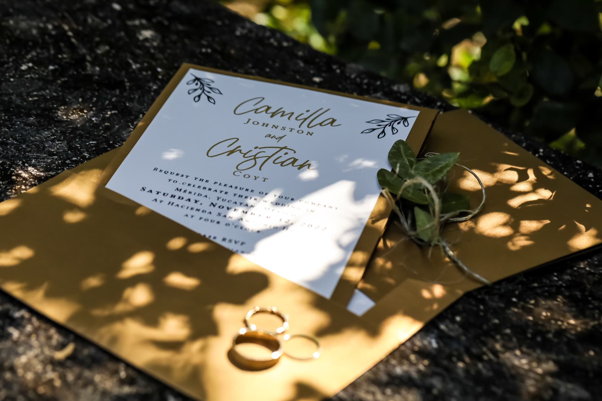 Invitación de boda de Camilla y Cristian acompañada por sus argollas doradas