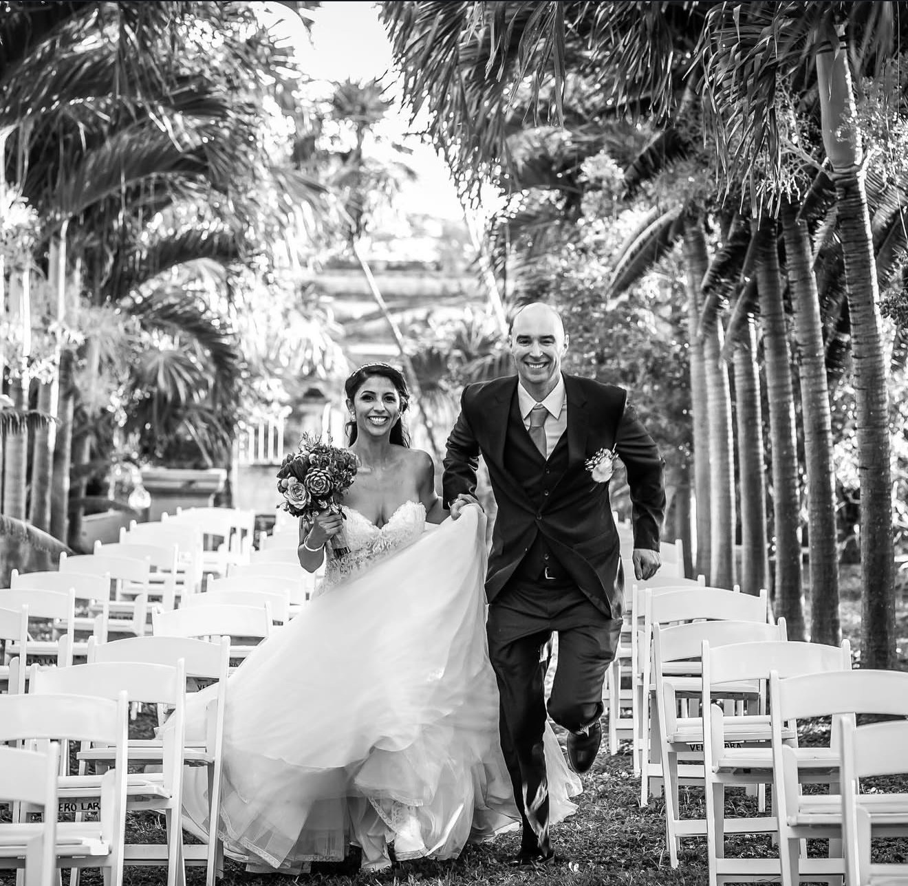 Novios corriendo entre palmeras tras la ceremonia, fotografía de boda destino